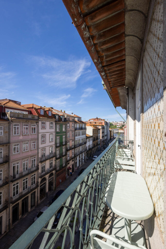 Fotógrafo de interiores no Porto: Quarto de alojamento local com varanda e pedra rústica.