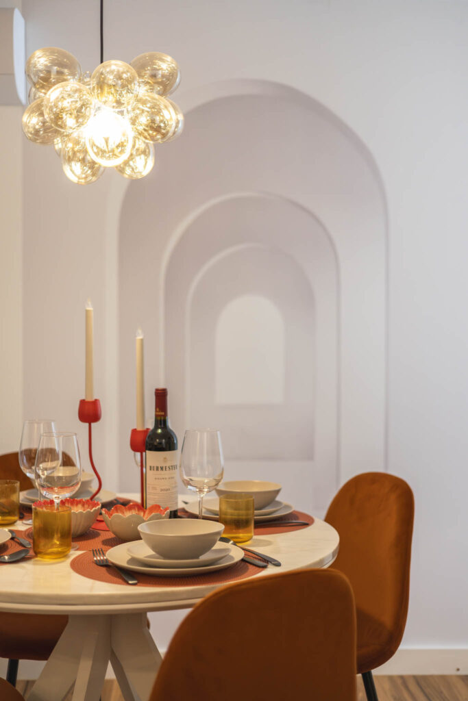 Fotografia de interiores no Porto: Detalhe de mesa de jantar iluminada com candeeiros de design.