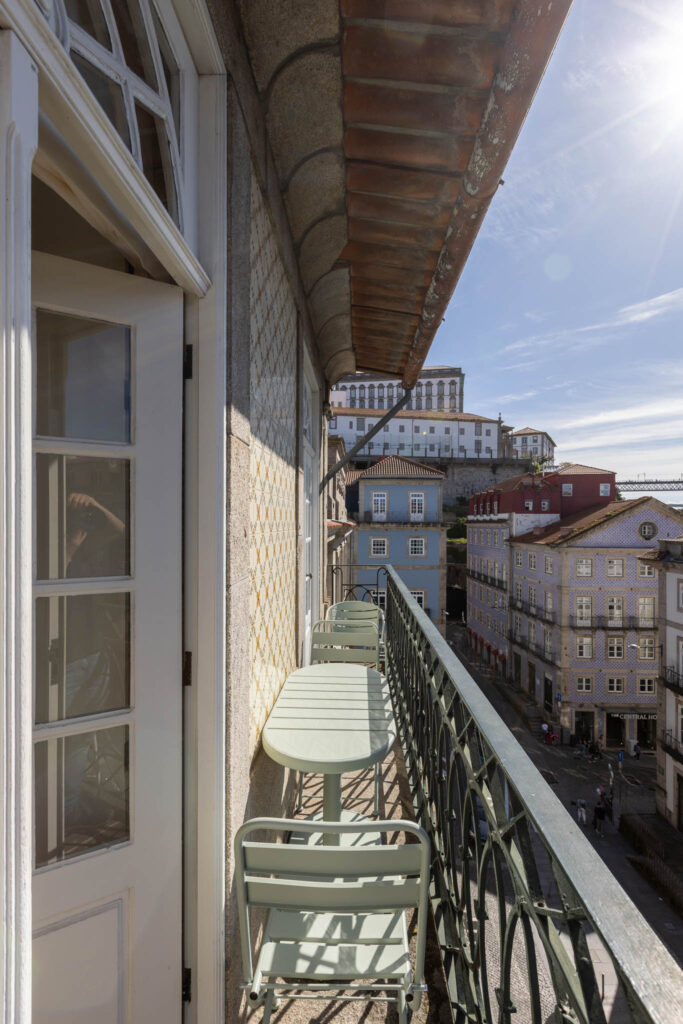 Fotógrafo de interiores no Porto: Quarto de alojamento local com varanda e pedra rústica.
