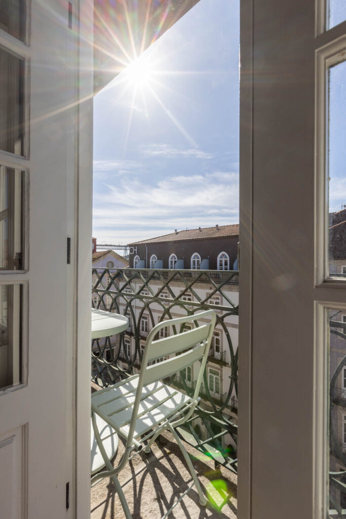 Fotógrafo de interiores no Porto: Quarto de alojamento local com varanda e pedra rústica.