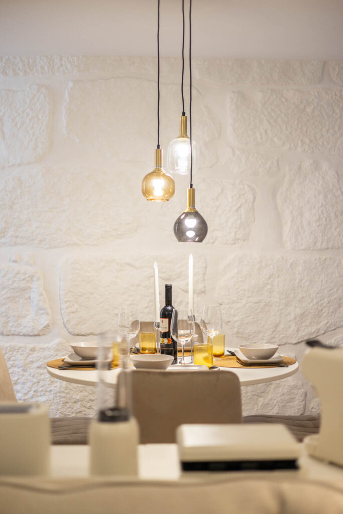 Fotografia de interiores no Porto: Detalhe de mesa de jantar iluminada com candeeiros de design.