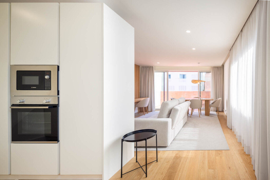 Cozinha integrada e sala de estar em plano aberto com luz natural e acesso a terraço, fotografia de interiores Matosinhos