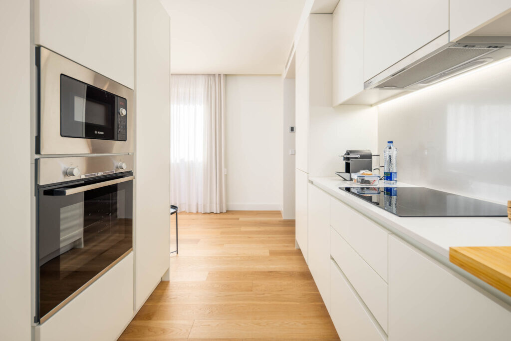 Cozinha equipada em linha branca com eletrodomésticos embutidos e pavimento em carvalho, apartamento Home Me