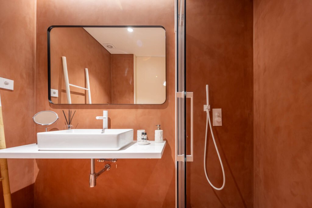 Casa de banho terracota com espelho rectangular e duche em vidro