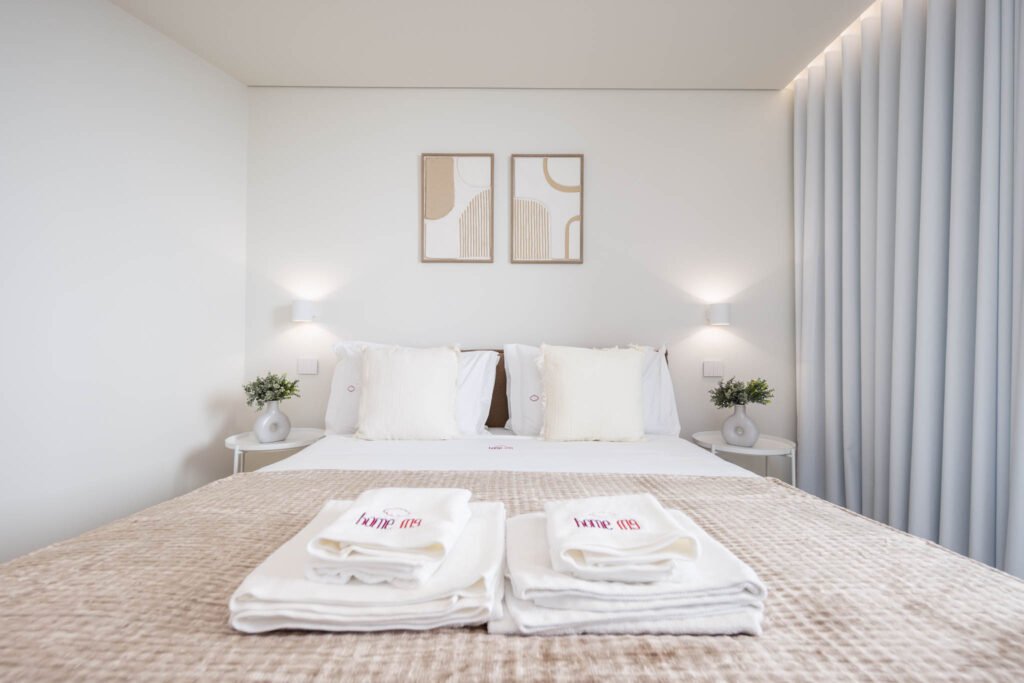 Cama de casal com manta texturada e toalhas bordadas Home me