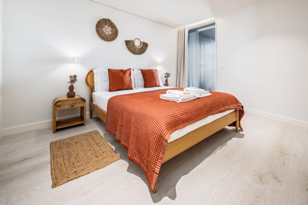 Quarto com manta terracota, cama em madeira e tapete natural